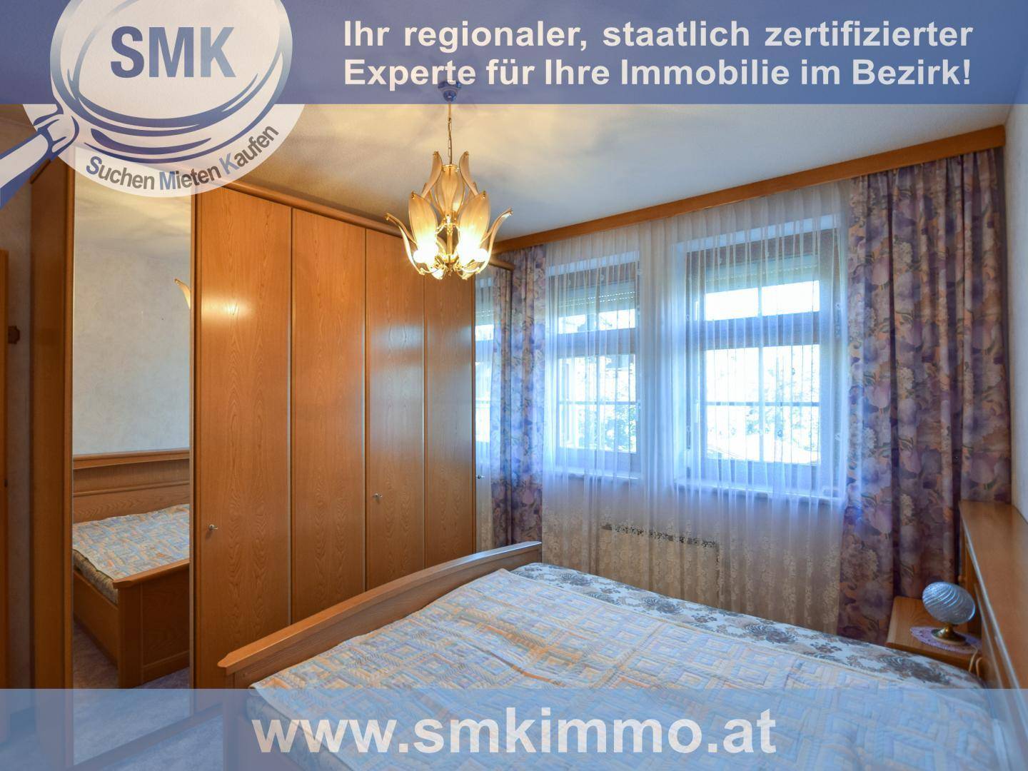 Gemütliches Schlafzimmer mit Doppelbett, großem Holzschrank und Fenstern mit Vorhängen.