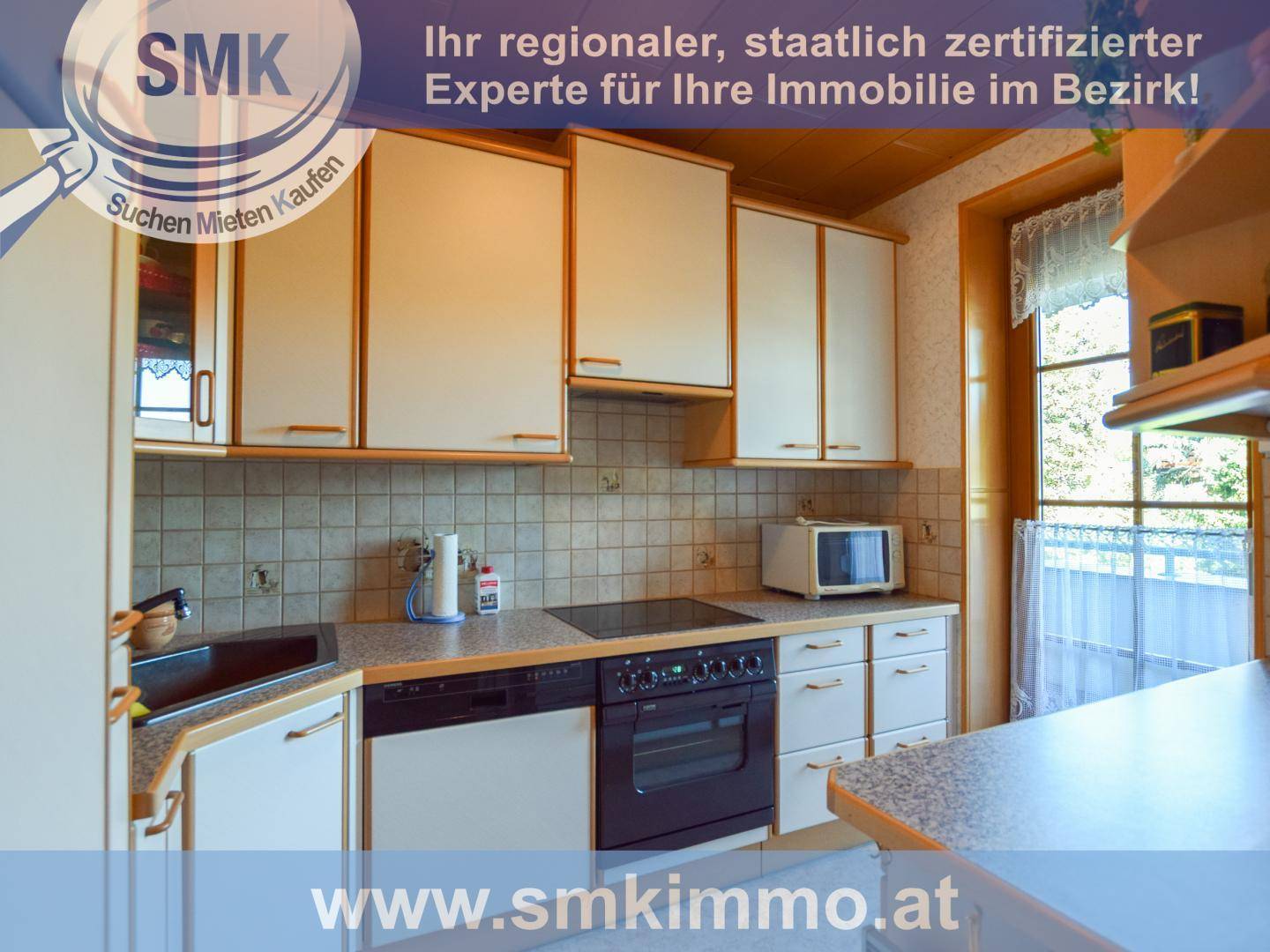 Funktionale Küche mit hellen Schränken, Fliesenrückwand und integrierten Elektrogeräten.