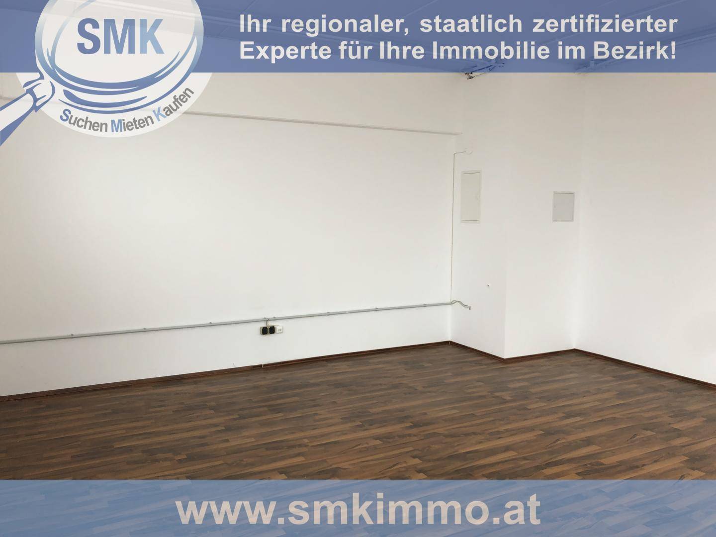 Leerer, sauberer Raum mit weißen Wänden und dunklem Laminatboden, bereit für die individuelle Gestaltung.