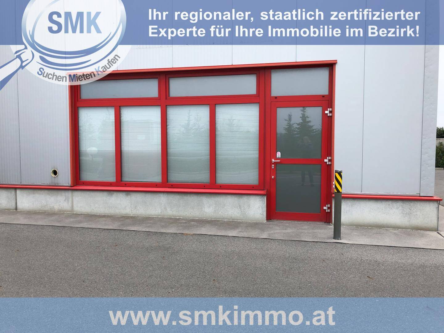 Nahaufnahme der roten Fenster und Tür eines modernen Geschäftsgebäudes mit Jalousien und einem Poller.