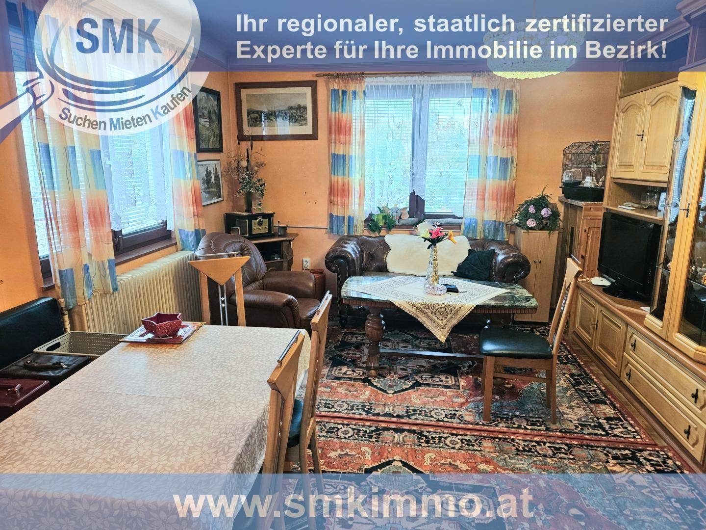 Gemütlicher Wohn-Essbereich mit traditionellen Möbeln, Teppich und Fensterblick ins Grüne.