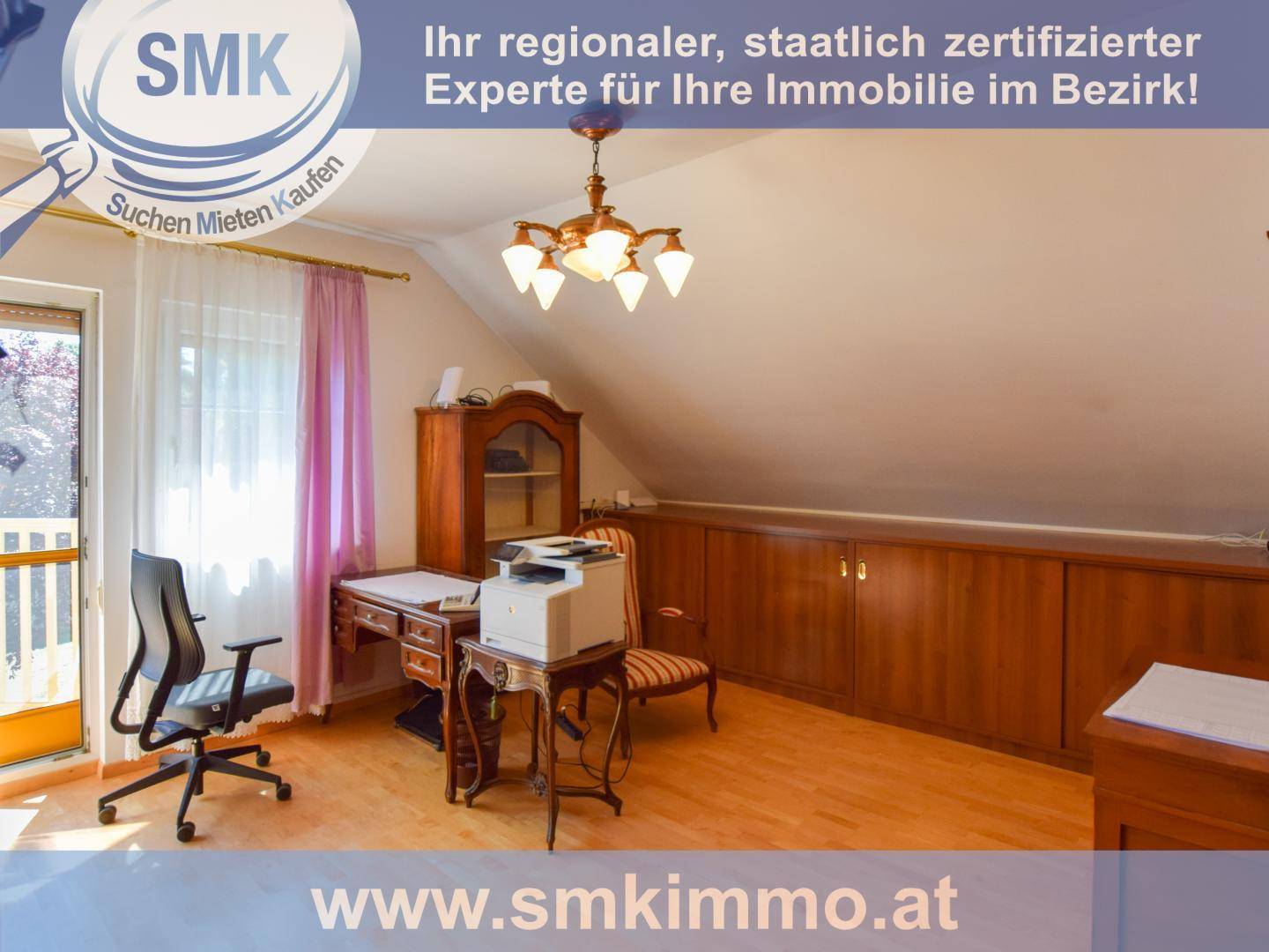 Dachgeschosszimmer mit Holzboden, Schreibtisch und integrierten Holzschränken unter der Dachschräge.