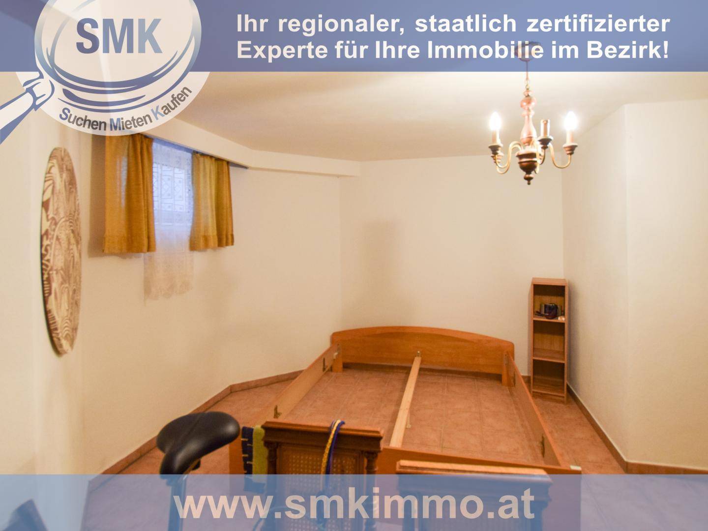 Schlafzimmer im Untergeschoss mit Fliesenboden und einem unfertigen Bettrahmen.