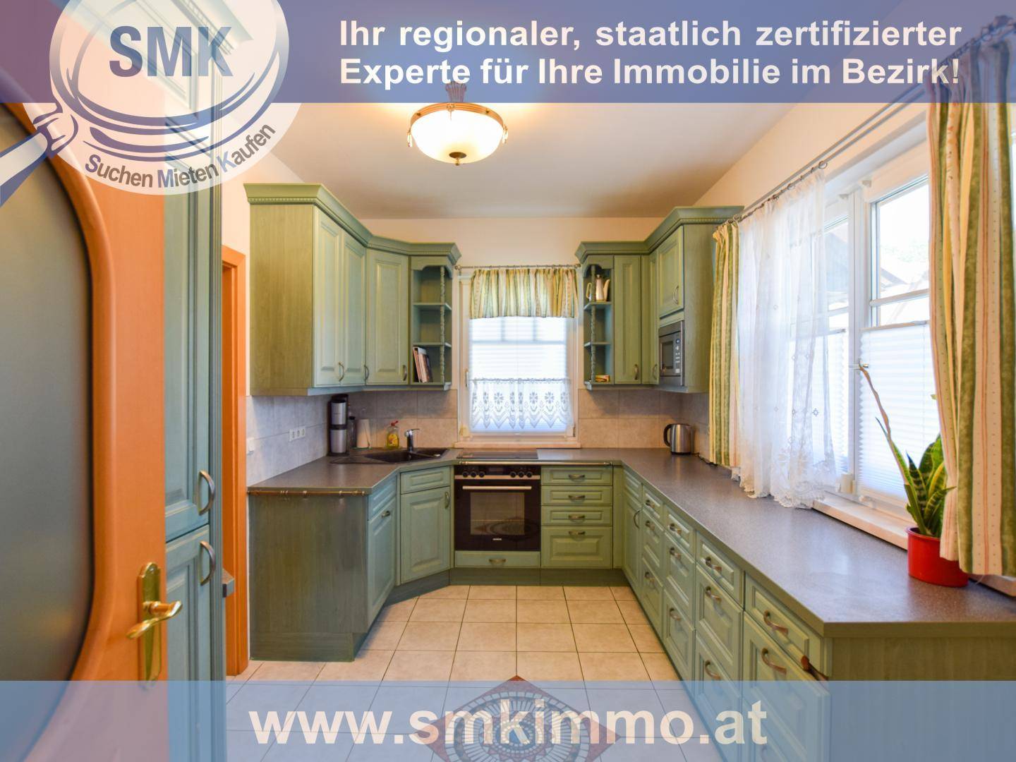 Grüne Einbauküche im Landhausstil mit integrierten Geräten und Fenster mit Blick ins Grüne.