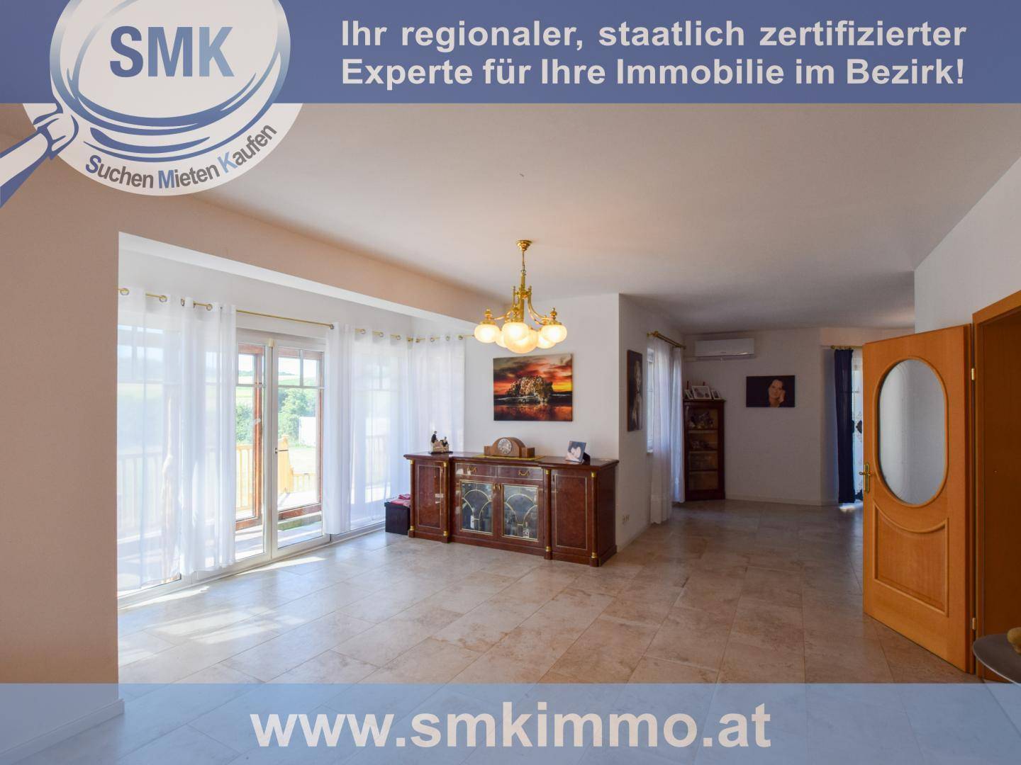 Helles Wohnzimmer mit Fliesenboden, großzügigen Fenstern und Zugang zu einem Außenbereich.