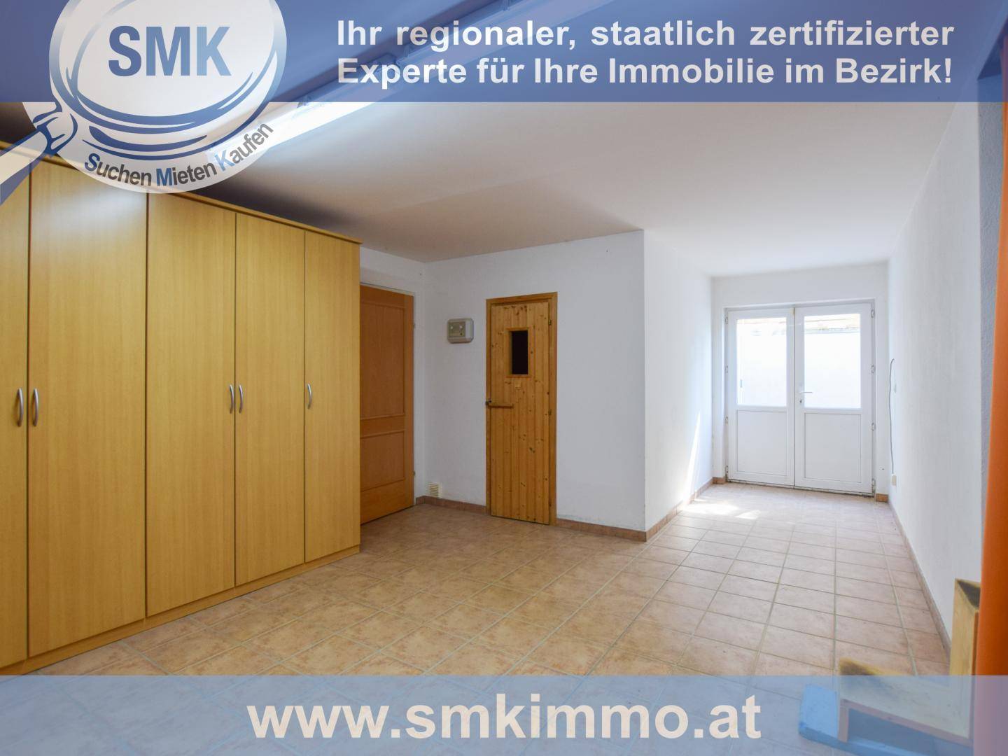 Geräumiger Raum mit Fliesenboden, Einbauschränken und Zugang zum Außenbereich.