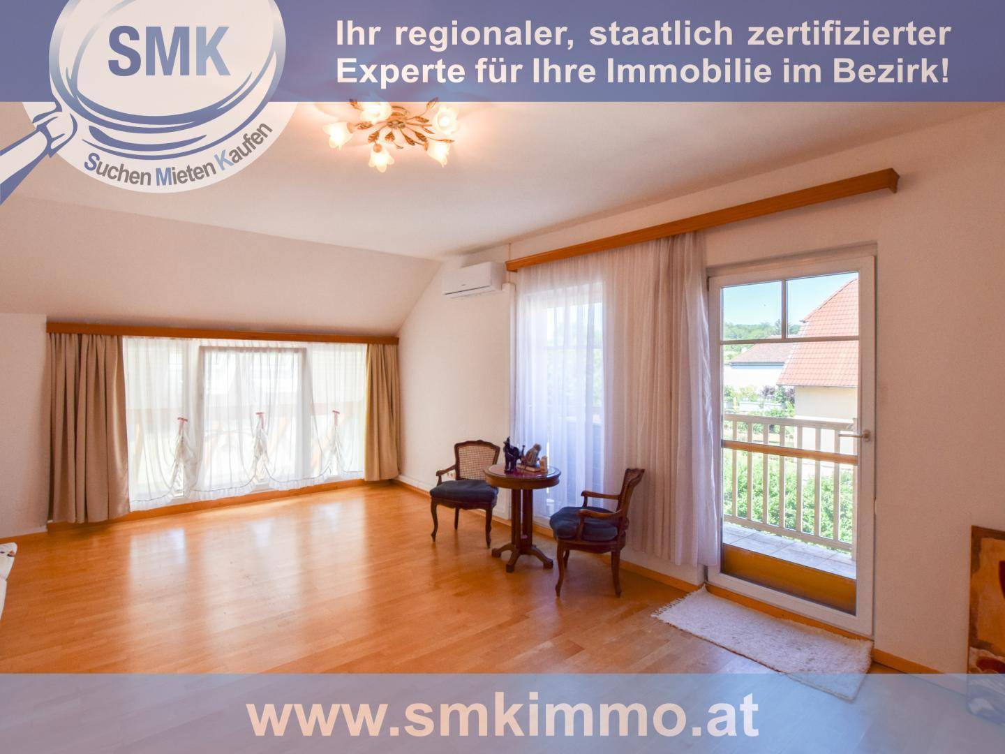 Helles Zimmer im Dachgeschoss mit Holzboden, Balkonzugang und schrägen Decken.