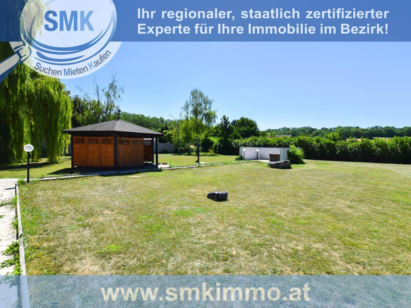 Großer, gepflegter Garten mit Rasenfläche, Bäumen und einem Holzpavillon zum Entspannen.