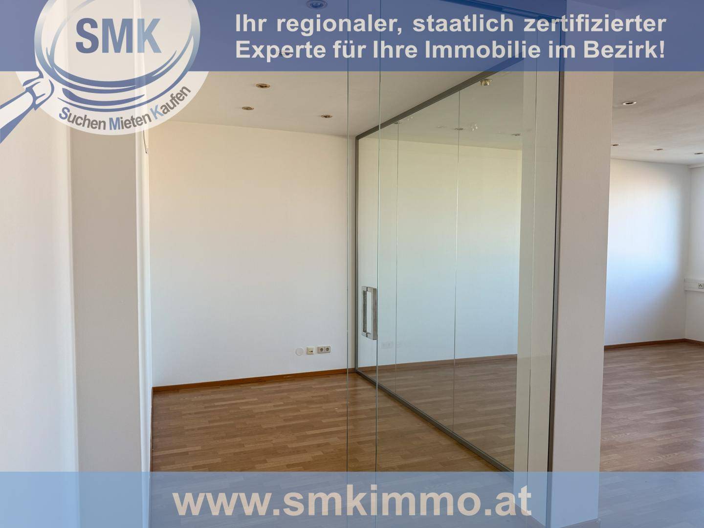 Innenraum mit Holzboden und einer eleganten Glaswand, die den Raum unterteilt.