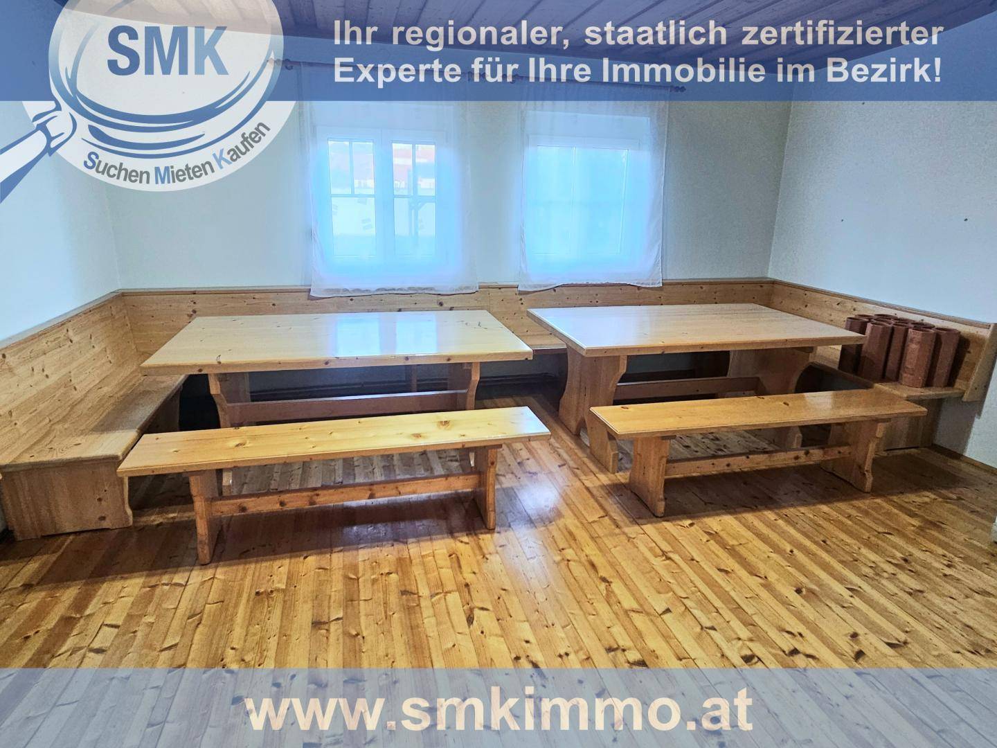 Rustikaler Essbereich mit Holztischen und Bänken, umgeben von Holzvertäfelungen.