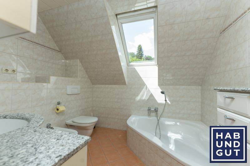 Badezimmer im Dachgeschoss mit Eckbadewanne, Bidet und Dachfenster.