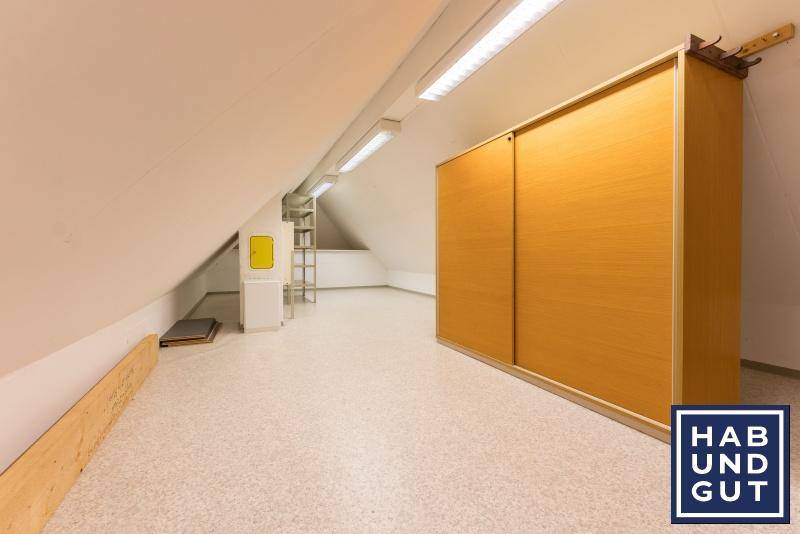 Geräumiger Dachboden als Abstellraum mit Einbauschrank und schrägen Wänden.