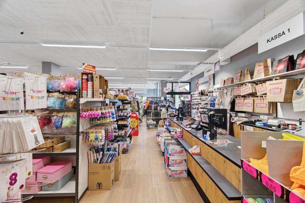 Kassenbereich im Woolworth-Geschäft mit verschiedenen Produkten und Geschenkartikeln.