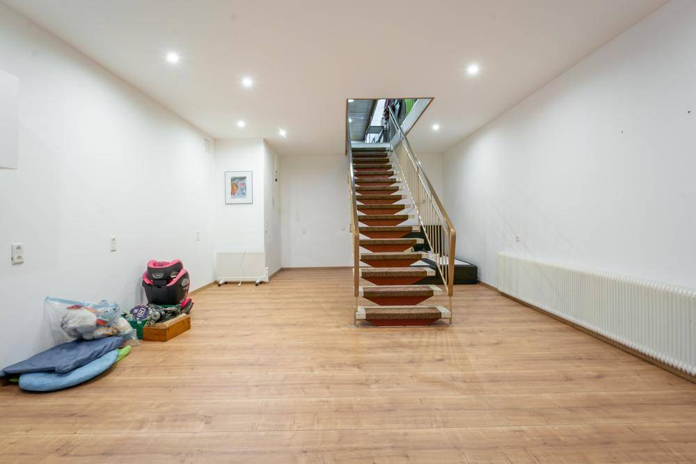 Heller Kellerraum mit Laminatboden und Treppe zum Obergeschoss.
