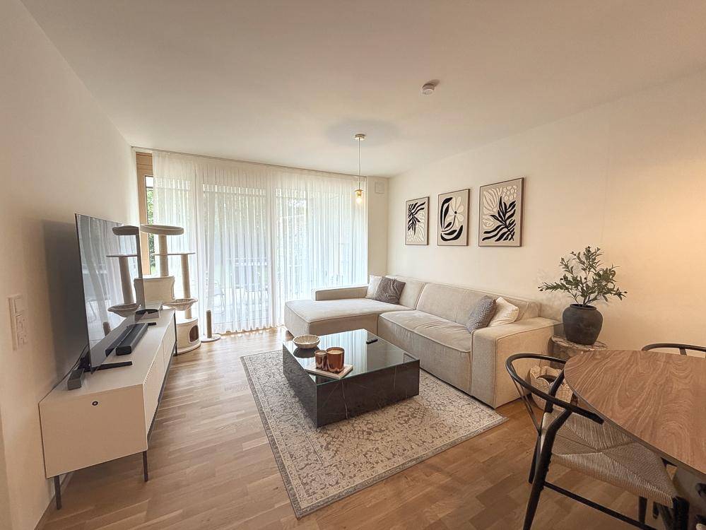Gemütlicher Wohnbereich mit Ecksofa, Couchtisch und Blick auf den Balkon.