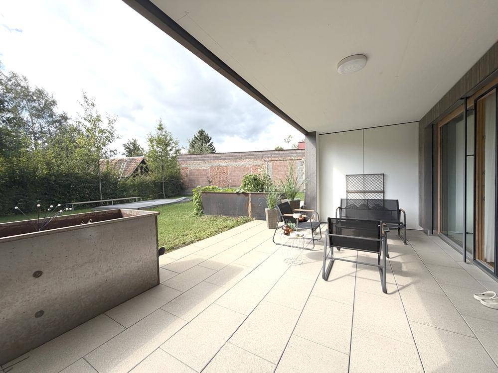 Geräumige Terrasse mit Sitzgelegenheiten und Blick ins Grüne.
