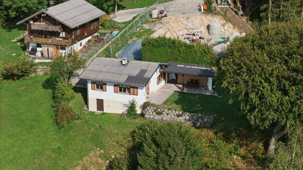 Luftaufnahme des Hauses mit Garten, angrenzendem Nachbarhaus und einer Baustelle.