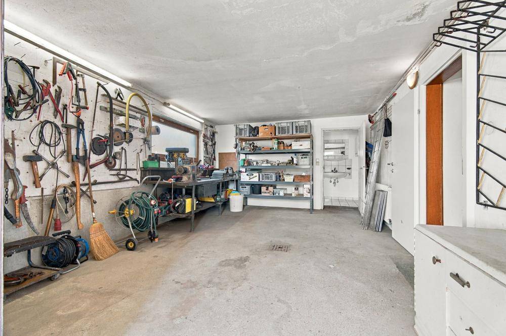 Geräumige Werkstatt oder Garage mit vielen Werkzeugen und Lagerregalen.