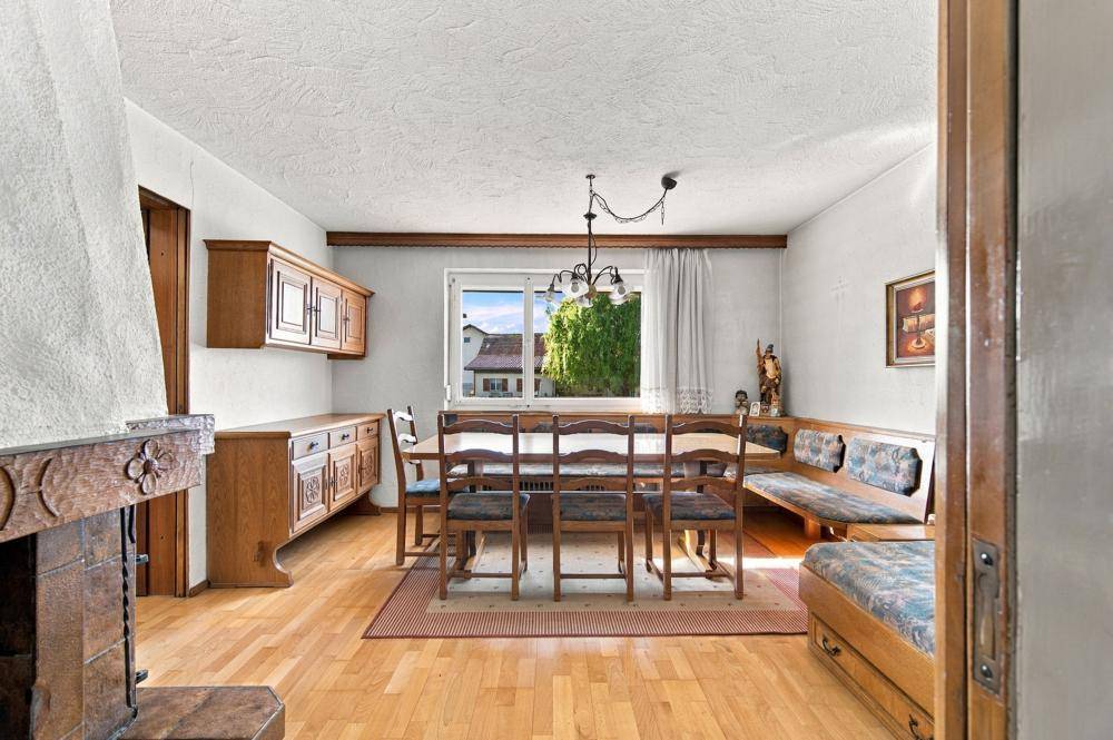 Traditioneller Essbereich mit Holztisch, Eckbank und Kamin im Landhausstil.
