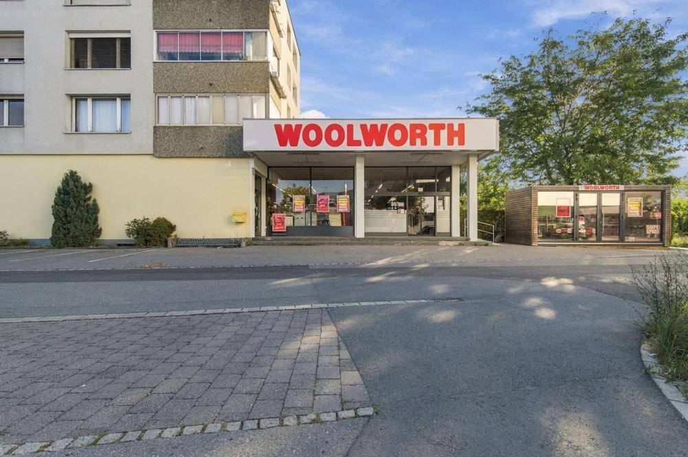 Eingangsbereich des Woolworth-Geschäfts mit großen Schaufenstern und dem darüber liegenden Wohngebäude.