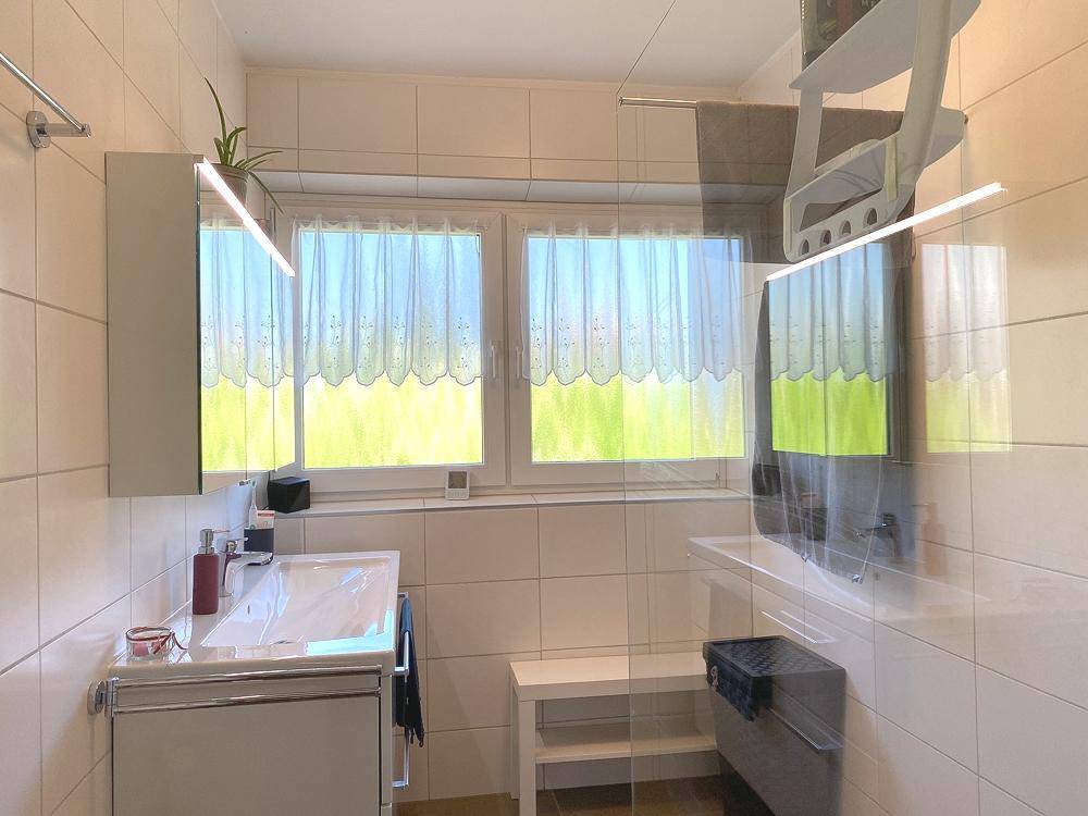 Badezimmer mit Dusche und Fenster