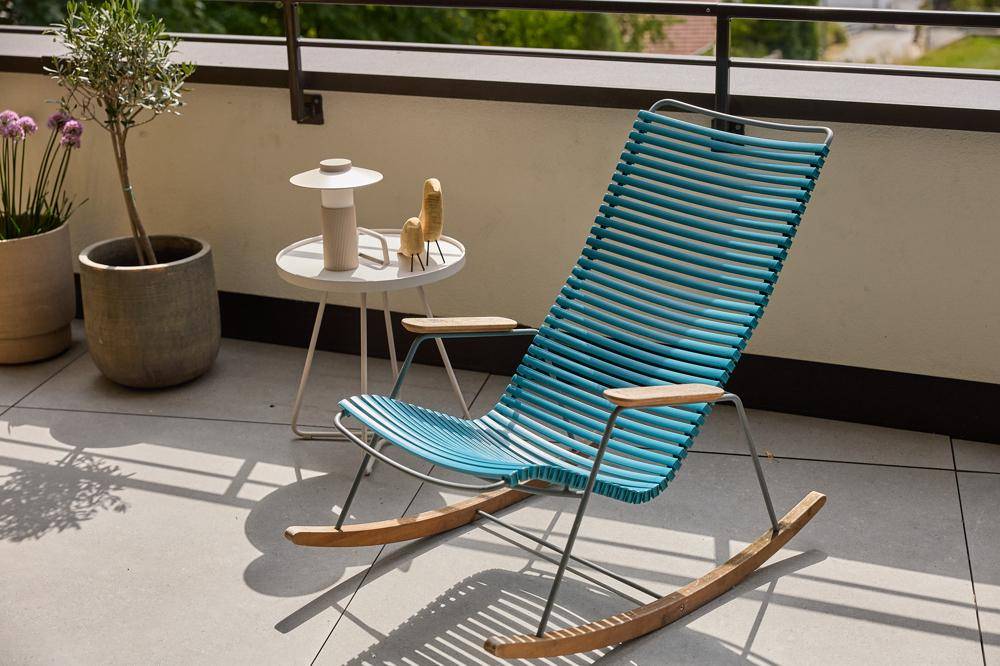 Sonniger Balkon mit modernen Outdoor-Möbeln und Blick ins Grüne.