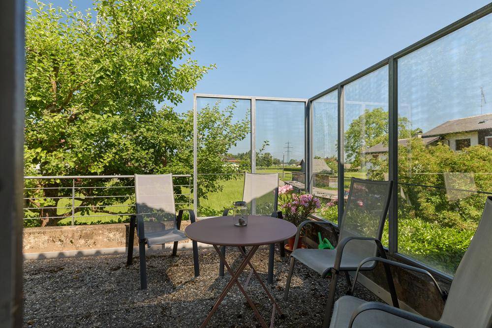 Sonniger Balkon mit Sitzgelegenheiten und weitem Blick ins Grüne.