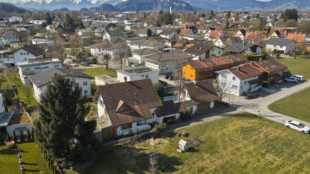 Weitläufige Luftaufnahme der Wohngegend mit Häusern und Bergen im Hintergrund.