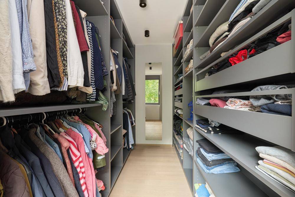 Geräumiger begehbarer Kleiderschrank mit vielen Regalen und Hängemöglichkeiten.
