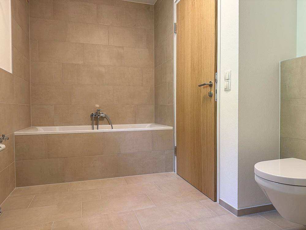 Badezimmer mit Badewanne, Dusche und Fenster