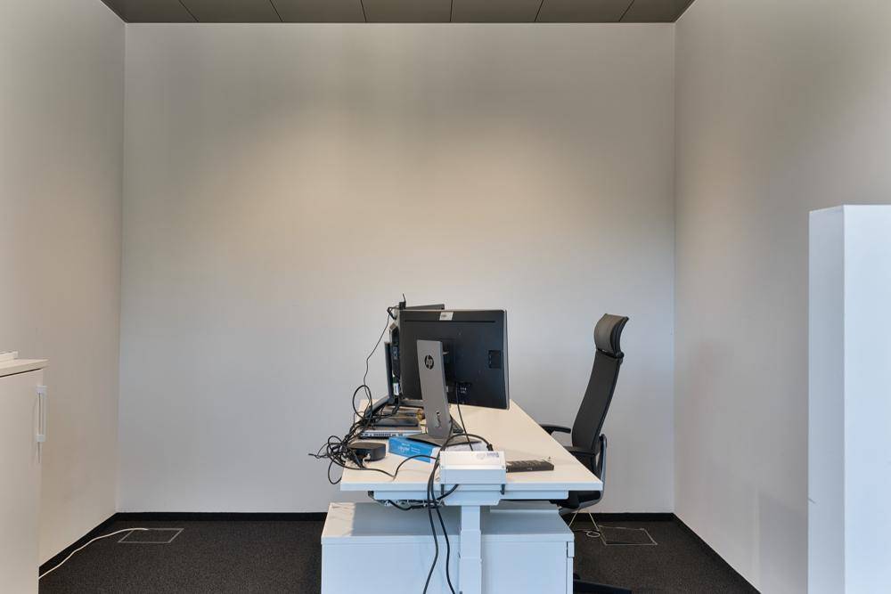 Einzelbüro mit modernem Schreibtisch, Bürostuhl und minimalistischer Einrichtung.