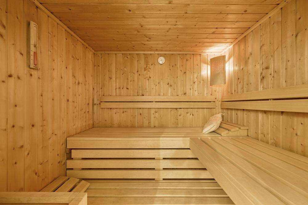 Holzverkleidete Sauna mit bequemen Bänken für entspannende Wellnessmomente.