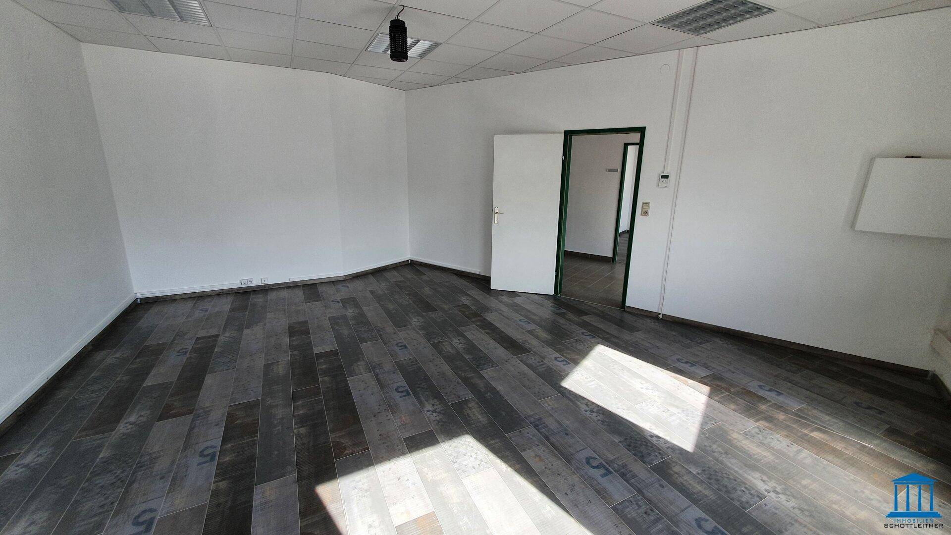 Geräumiges Büro mit Laminatboden und weiß gestrichenen Wänden, bereit zur Einrichtung.