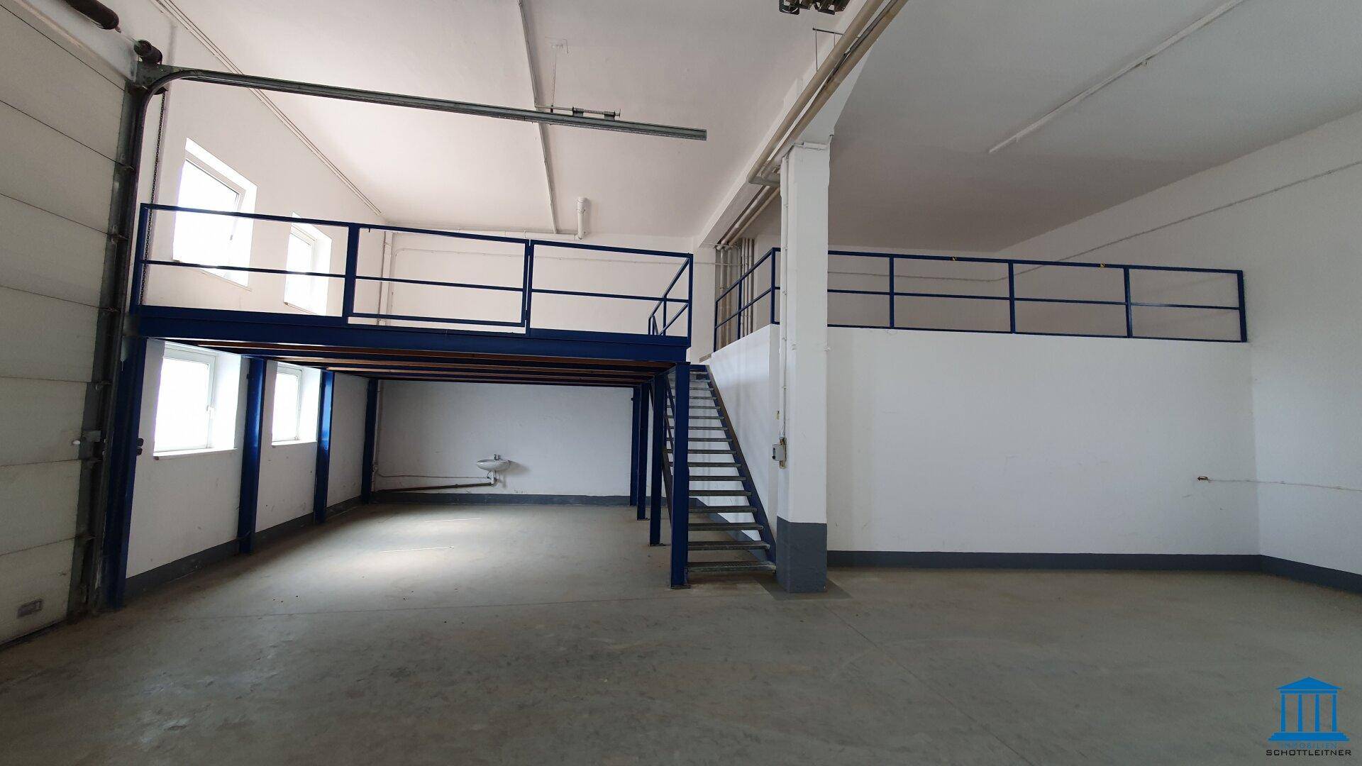 Blick auf die Mezzanine-Ebene mit blauen Geländern und Treppe in einem großen Lagerraum.