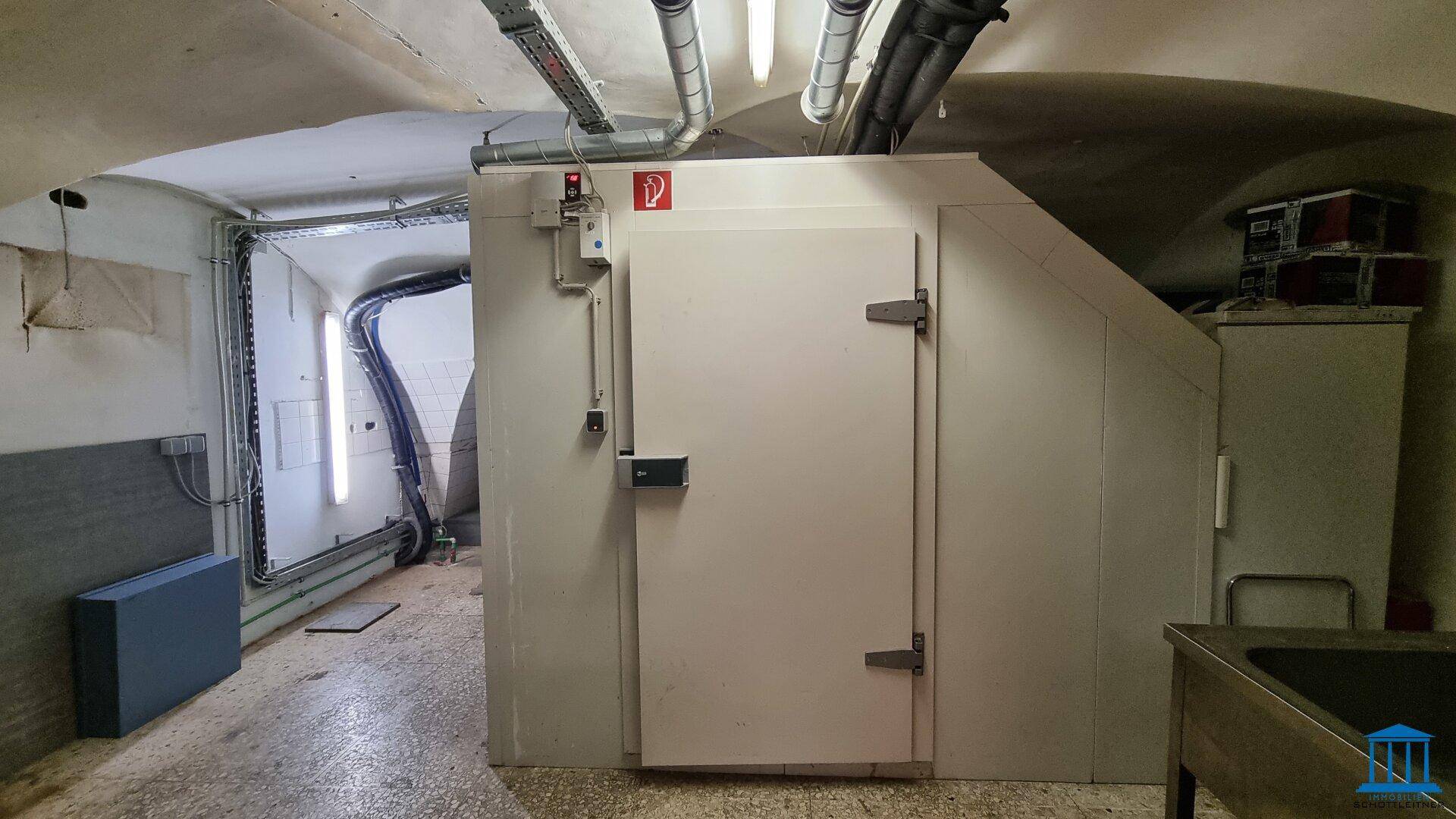 Lagerraum mit einer großen Kühlzelle und technischen Installationen an der Decke.