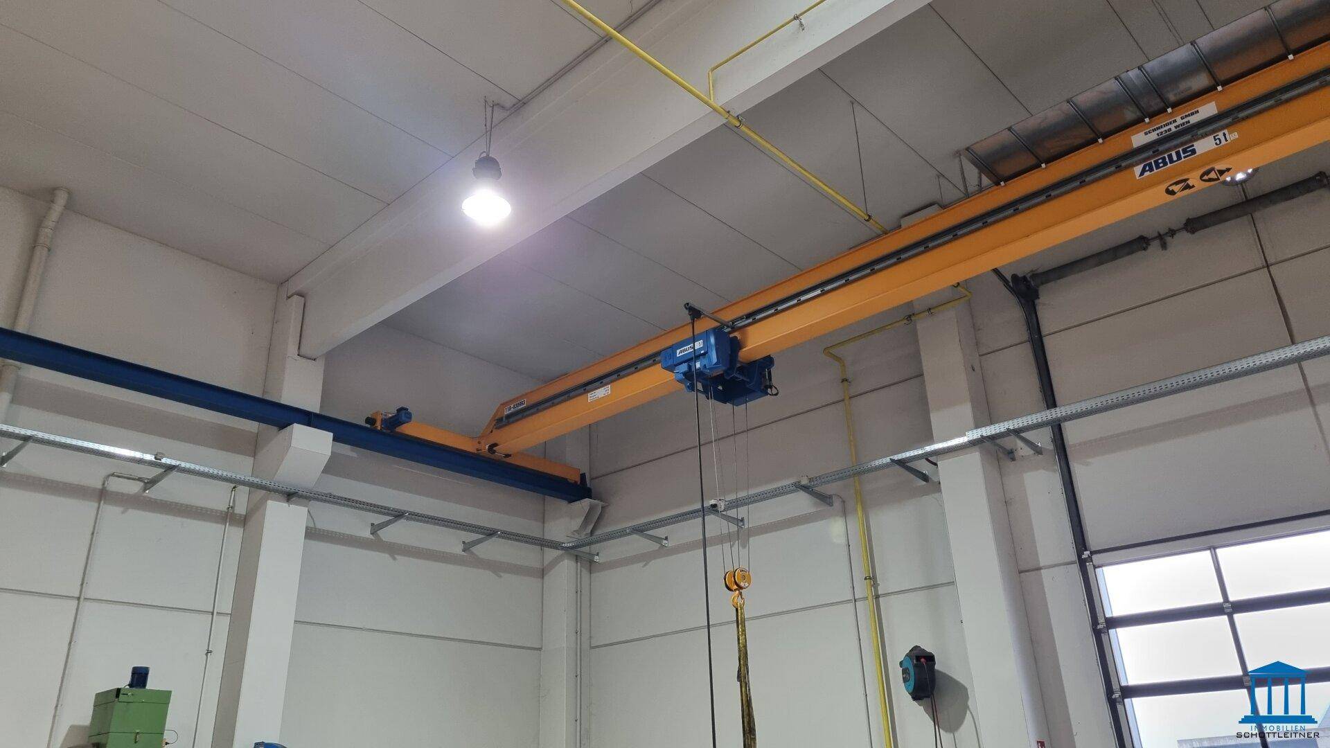 Industriedecke einer Lagerhalle mit Krananlage und Beleuchtung.