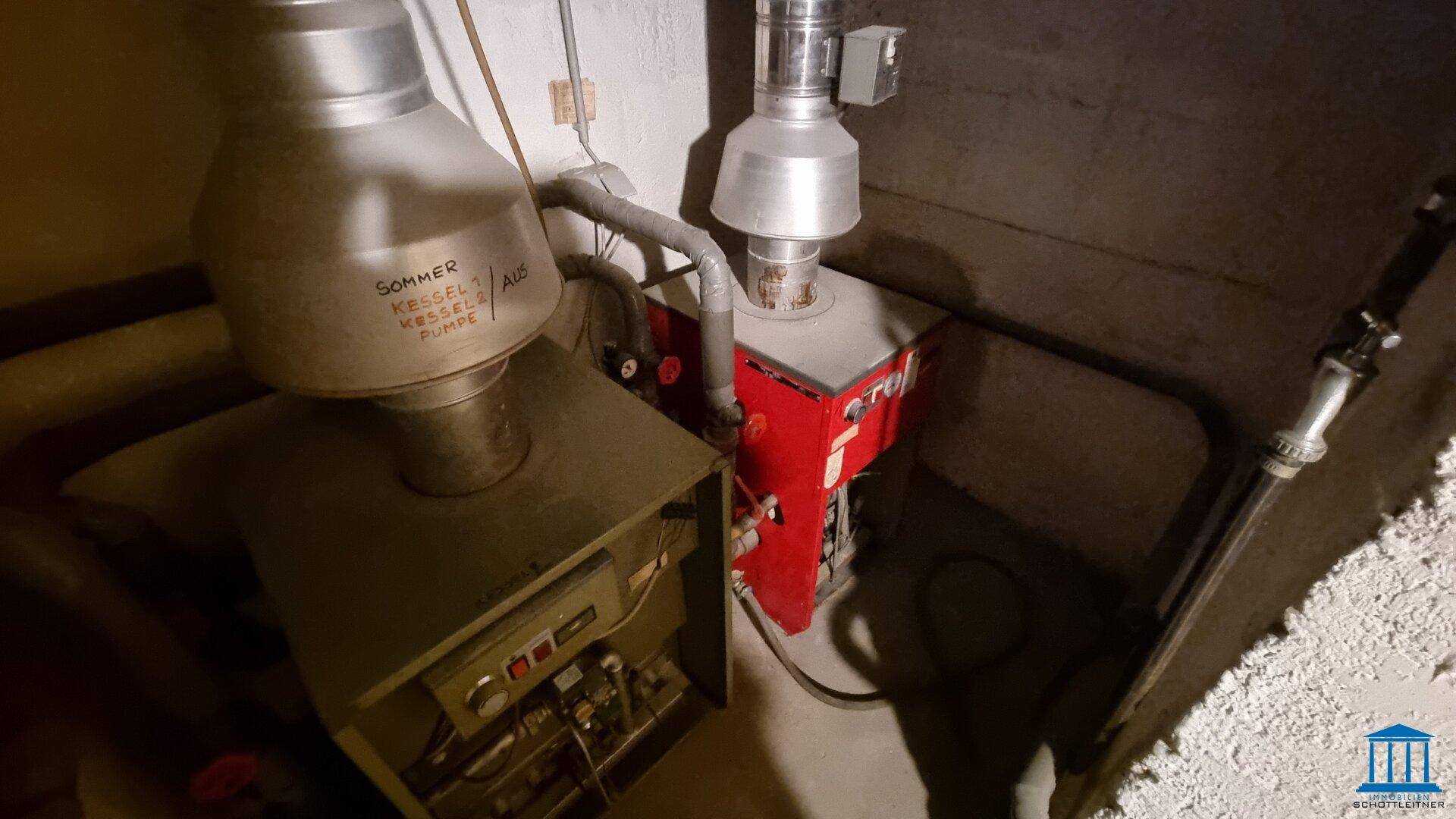 Detailansicht der Heizungsanlage im Keller mit zwei Kesseln und Rohrleitungen.