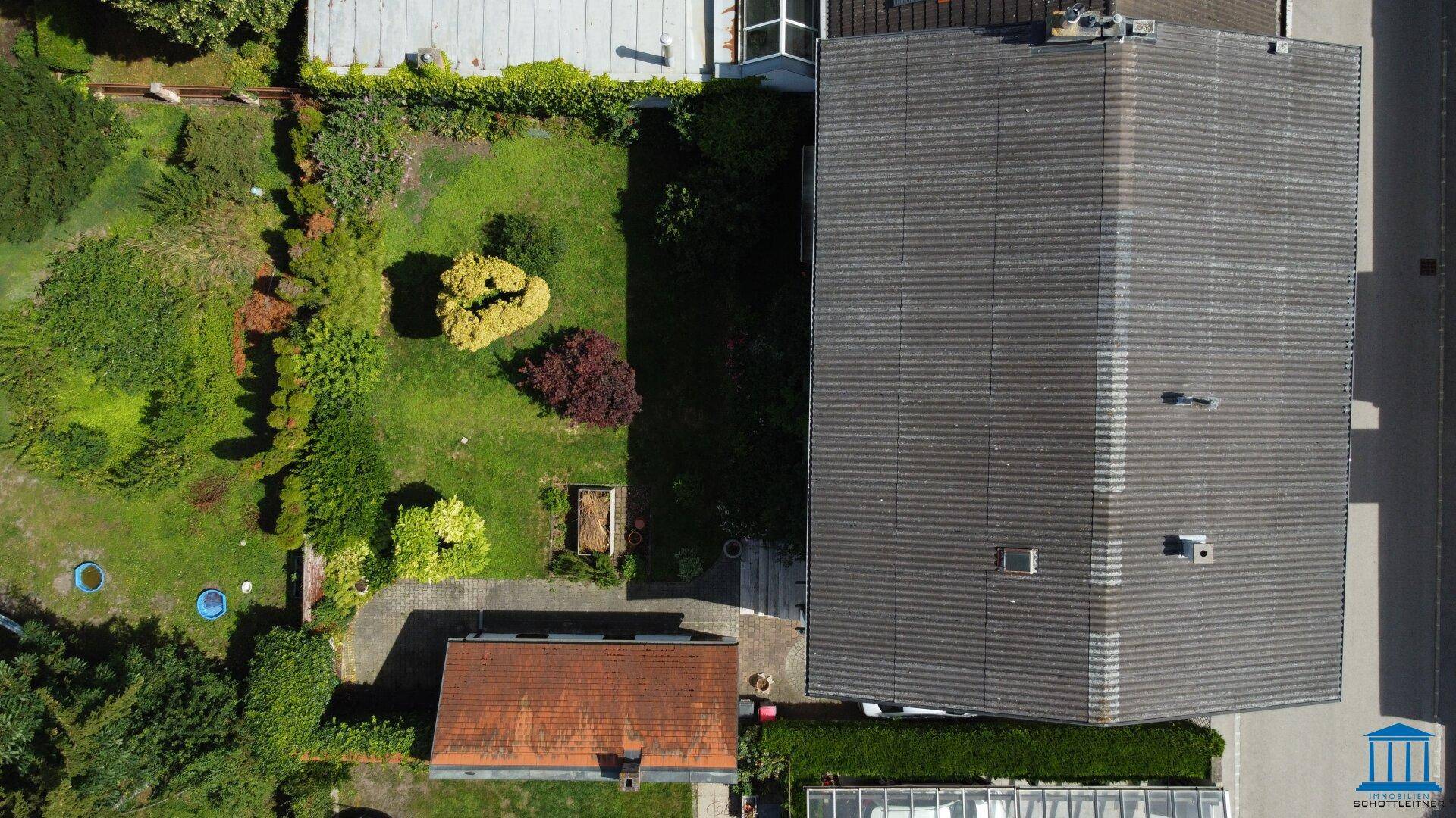 Luftaufnahme des gesamten Grundstücks mit Hauptgebäude, Nebengebäude und großem Garten.