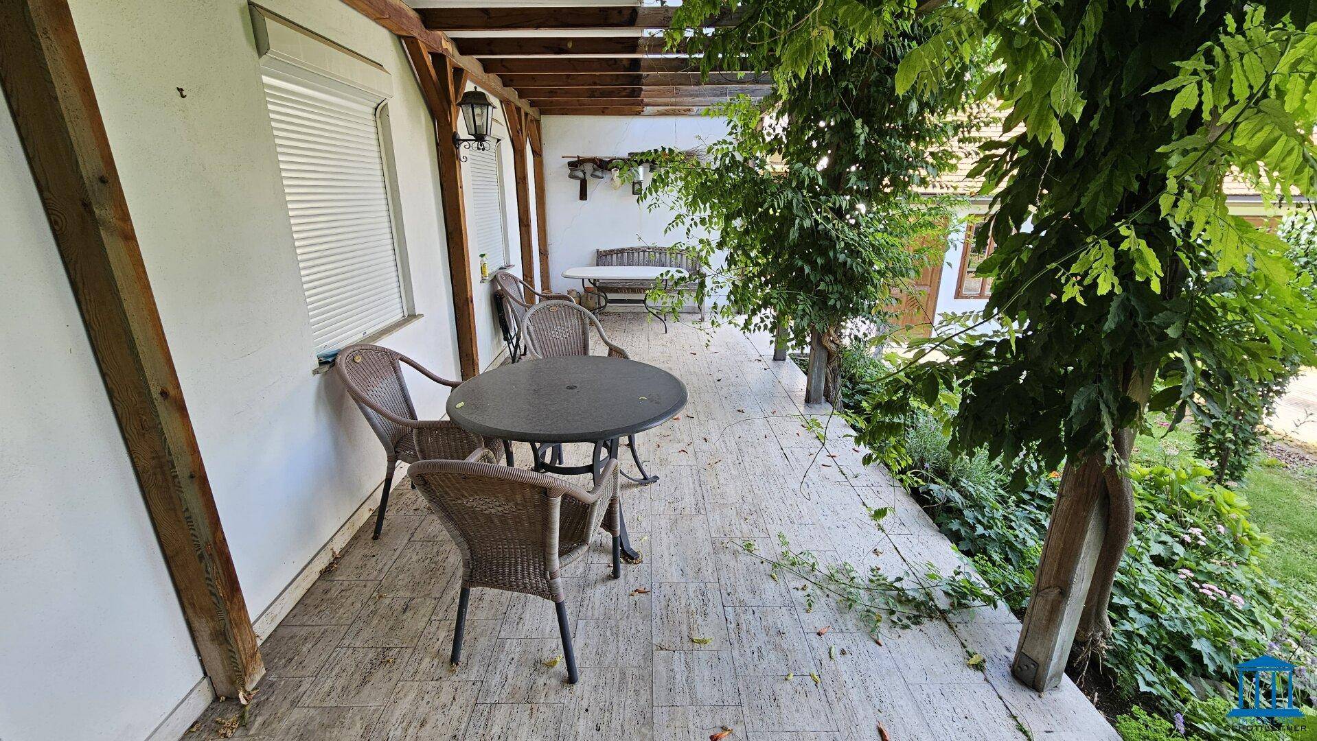 Überdachte Terrasse mit Gartenmöbeln, ideal für entspannte Stunden im Freien.