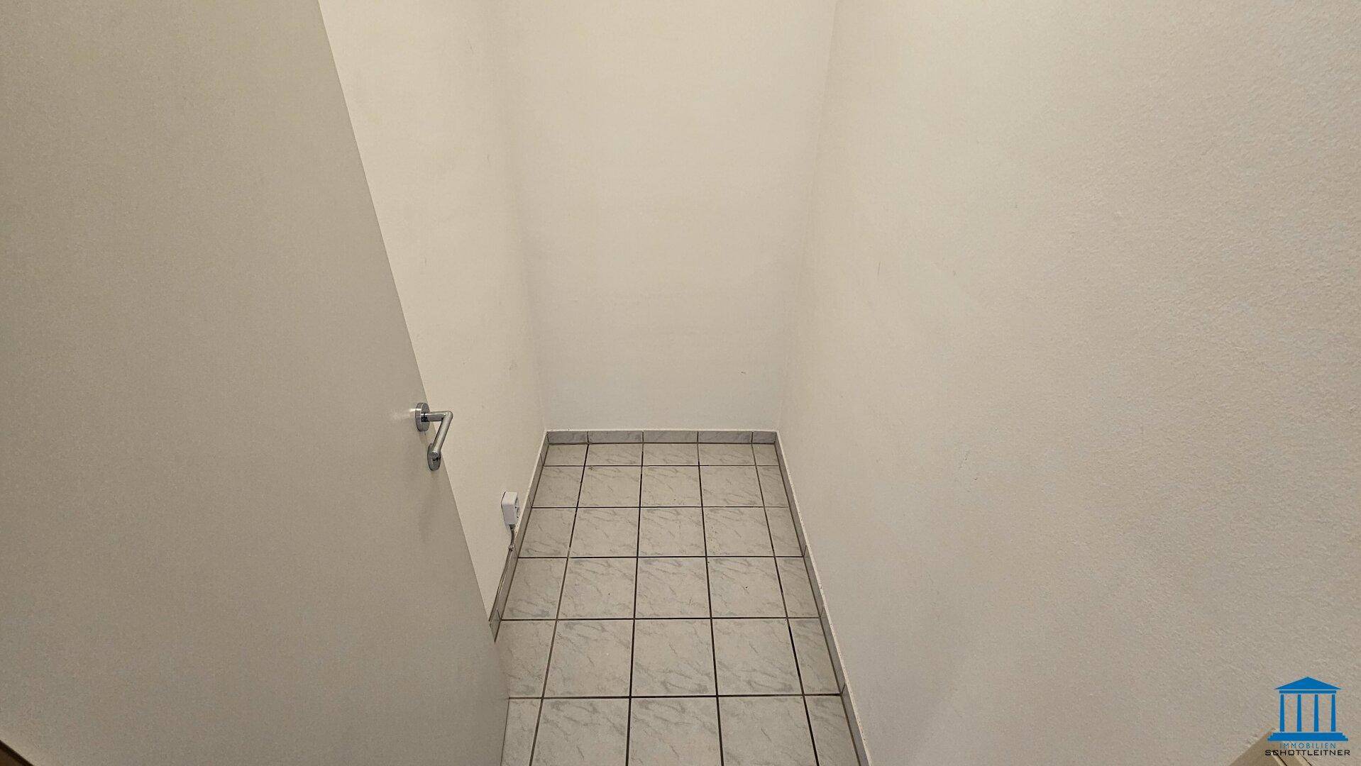 Kleiner Abstellraum mit Fliesenboden und weißen Wänden, ideal für zusätzlichen Stauraum.