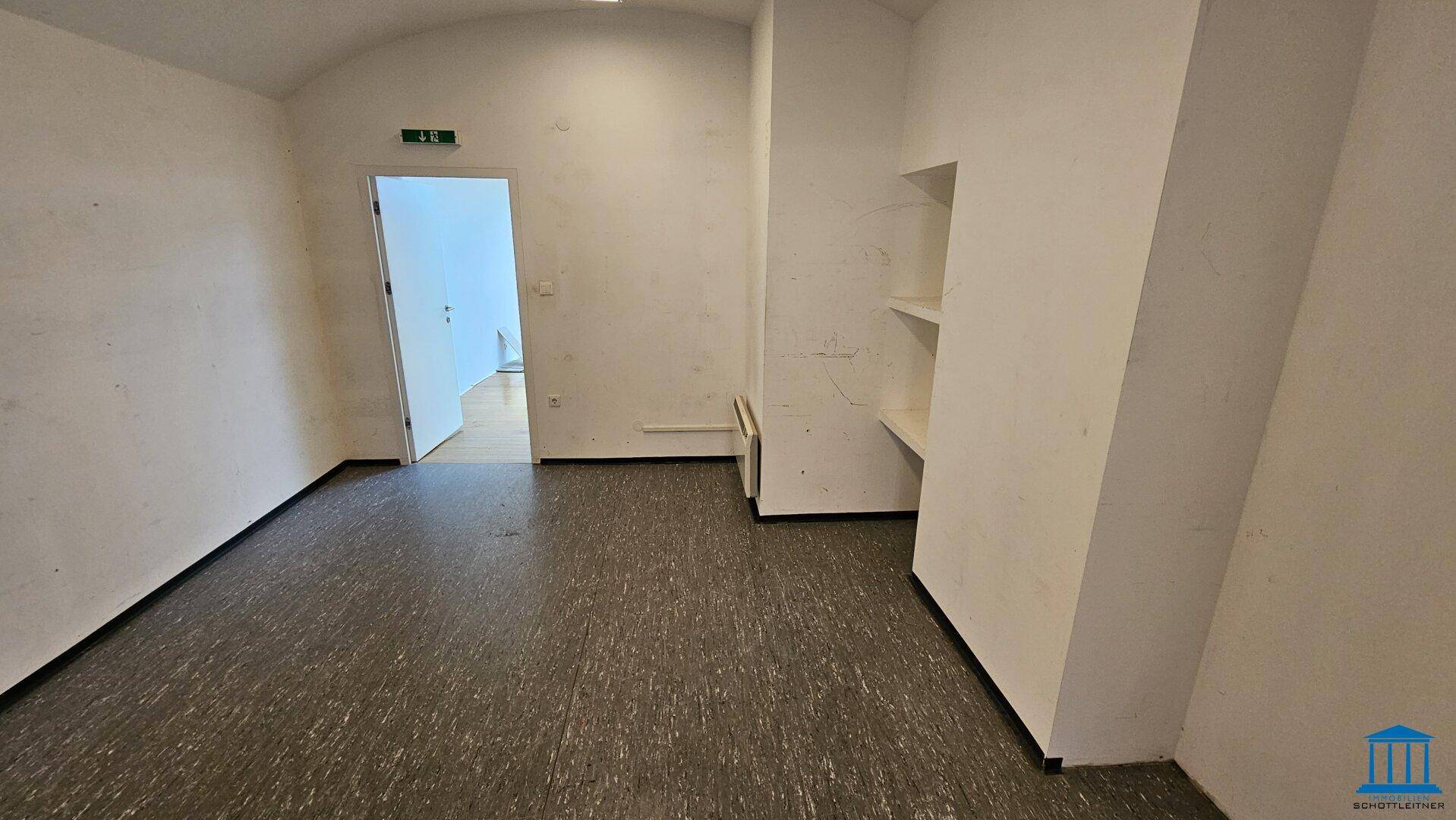 Schlichter Abstellraum mit Linoleumboden und eingebauten Regalnischen, ideal für Lagerzwecke.