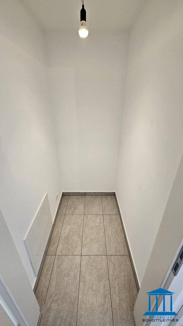 Kleiner Abstellraum mit Fliesenboden und hohen Wänden, ideal für zusätzlichen Stauraum.