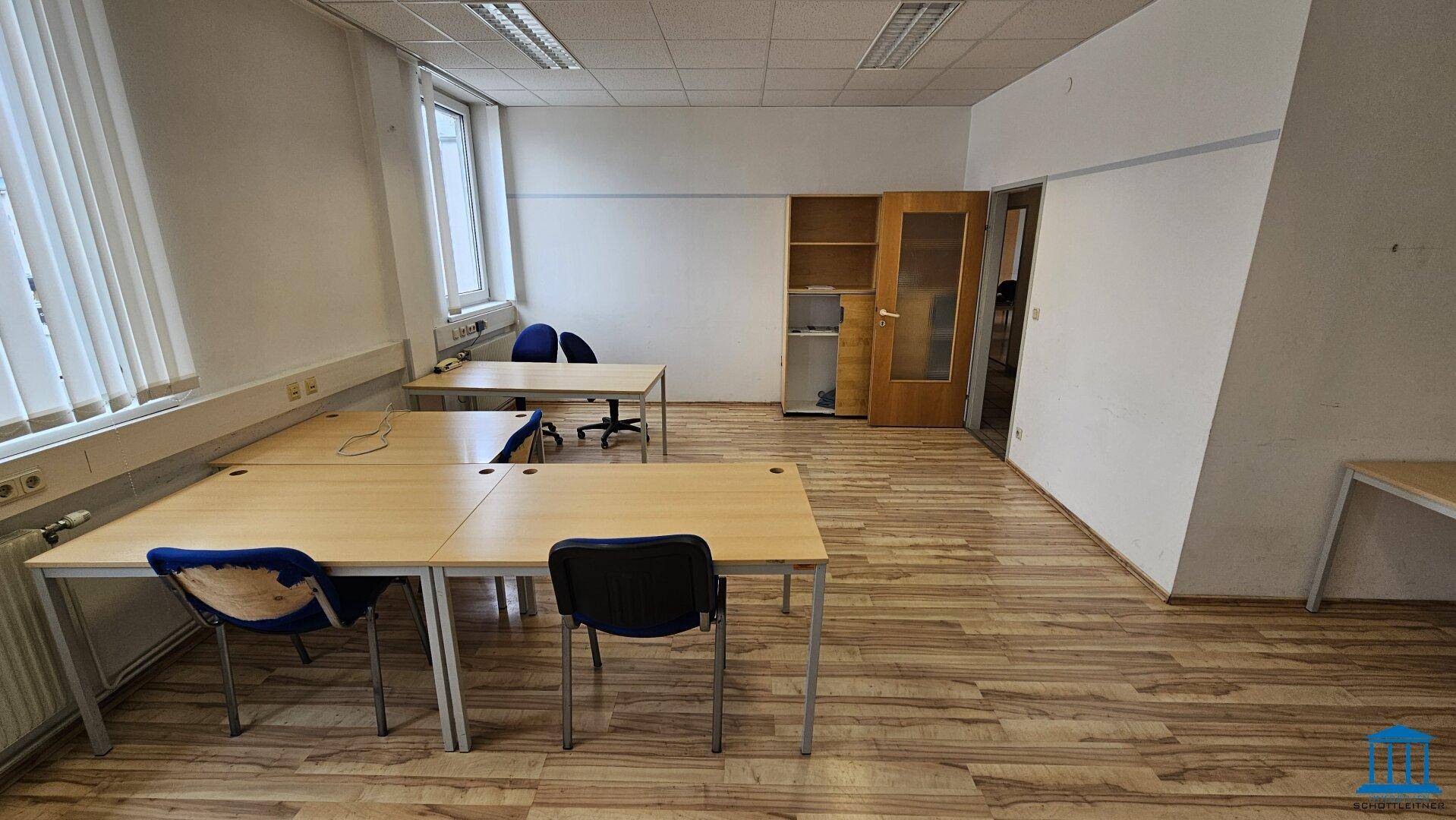 Helles Büro mit Tischen und Stühlen, ideal für Einzelarbeitsplätze oder kleine Teams.