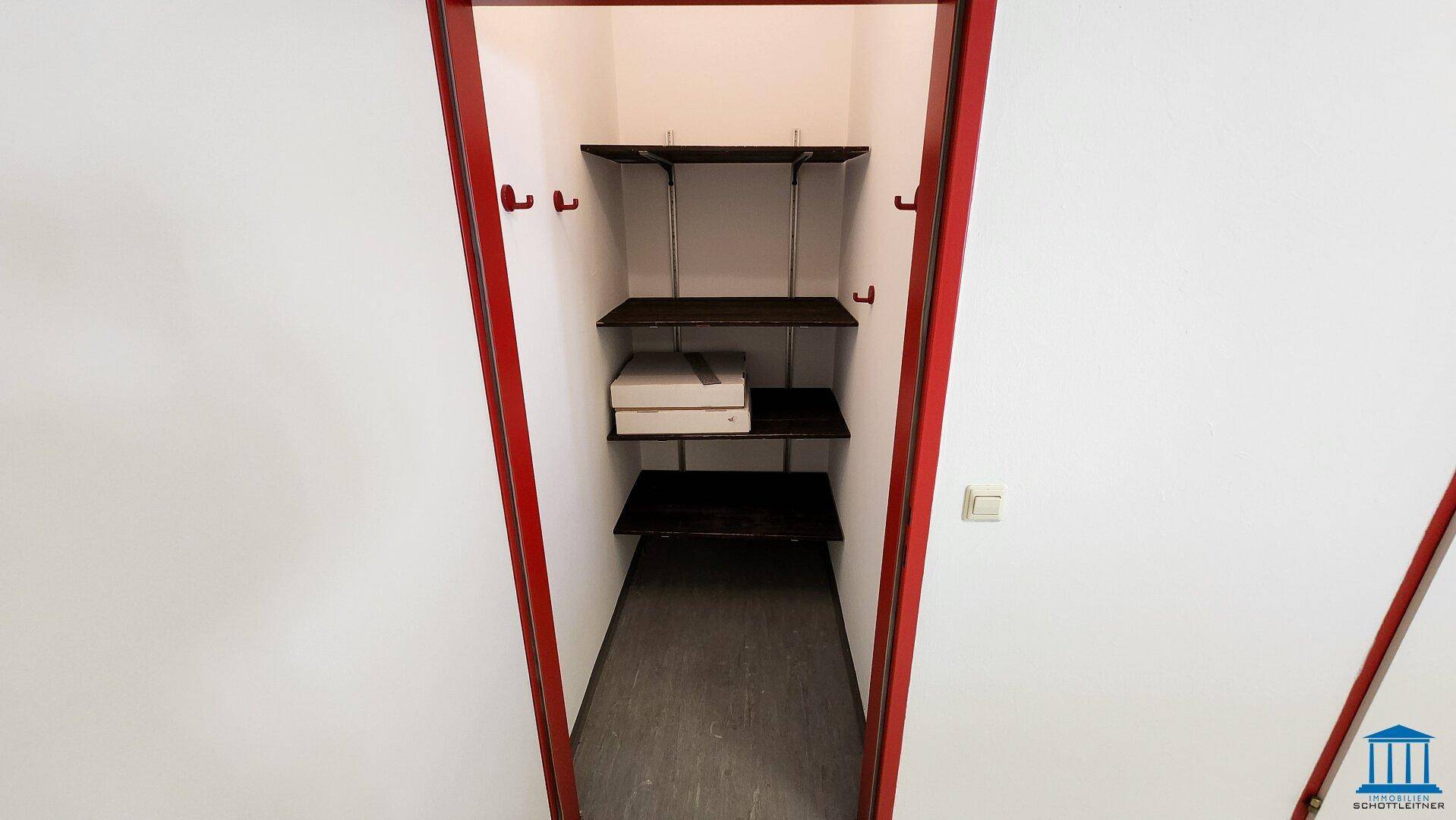 Kleiner Abstellraum mit Regalen und dunklem Boden, ideal für Lagerzwecke und Organisation.