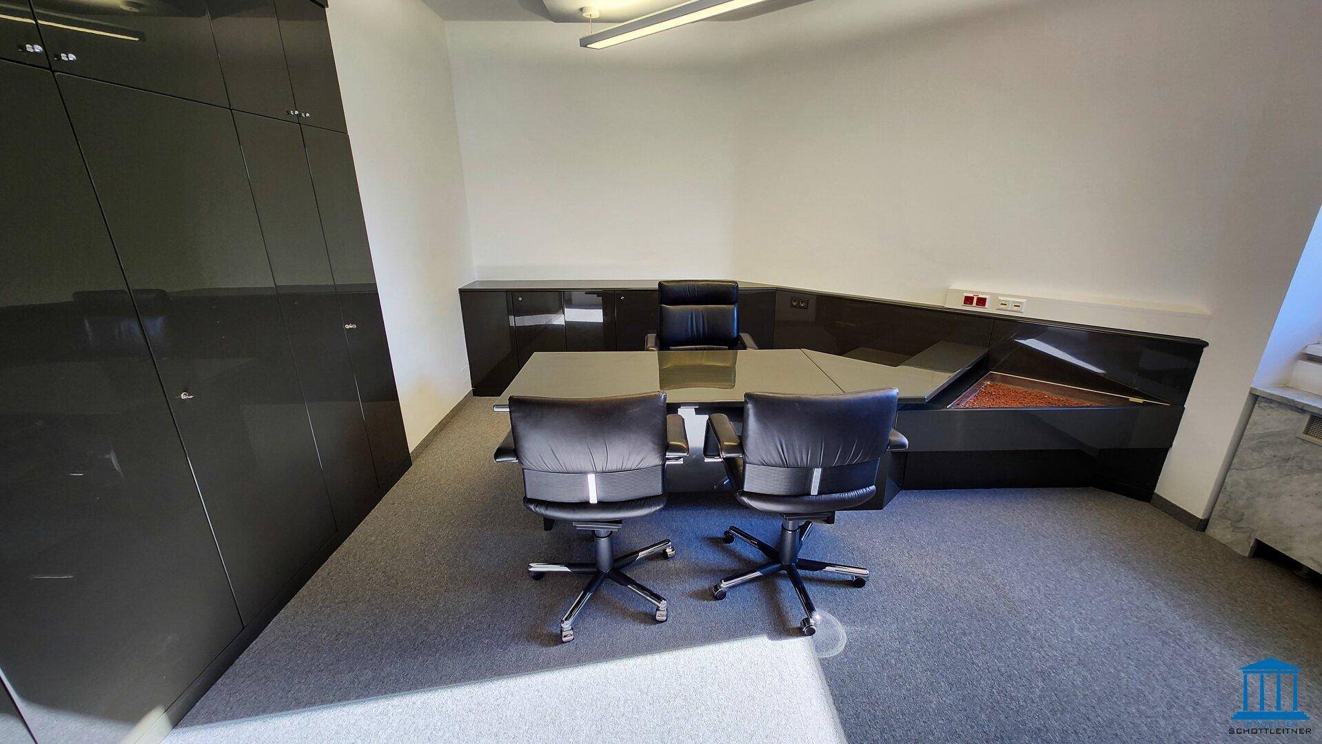 Modernes Chefbüro mit glänzendem schwarzem Schreibtisch und passenden Büroschränken, sehr stilvoll.