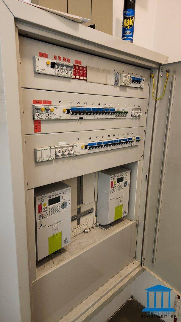 Elektrischer Verteilerkasten mit Sicherungen und Zählern, ordentlich installiert und zugänglich.