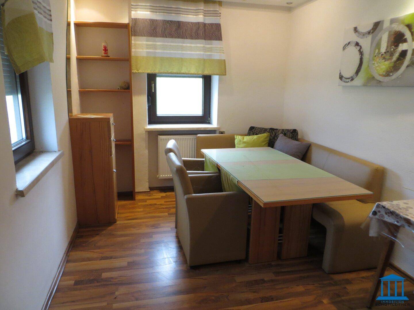 Essbereich mit Holztisch, Eckbank und Laminatboden.