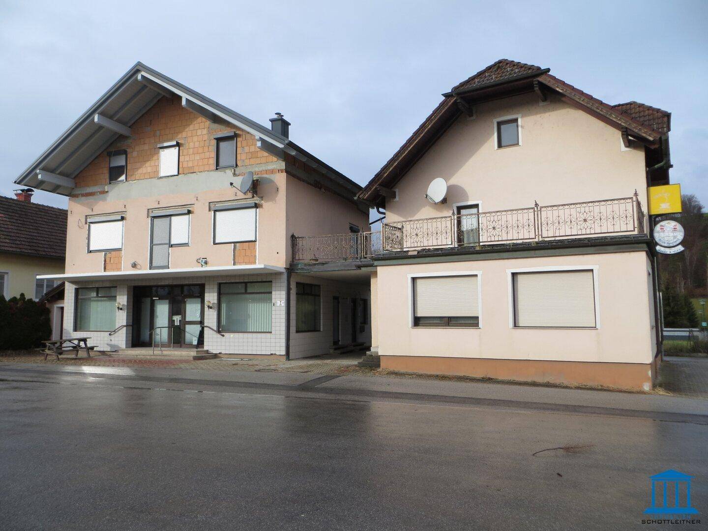 Gebäudeansicht von der Straße mit unfertiger Fassade und Balkon.