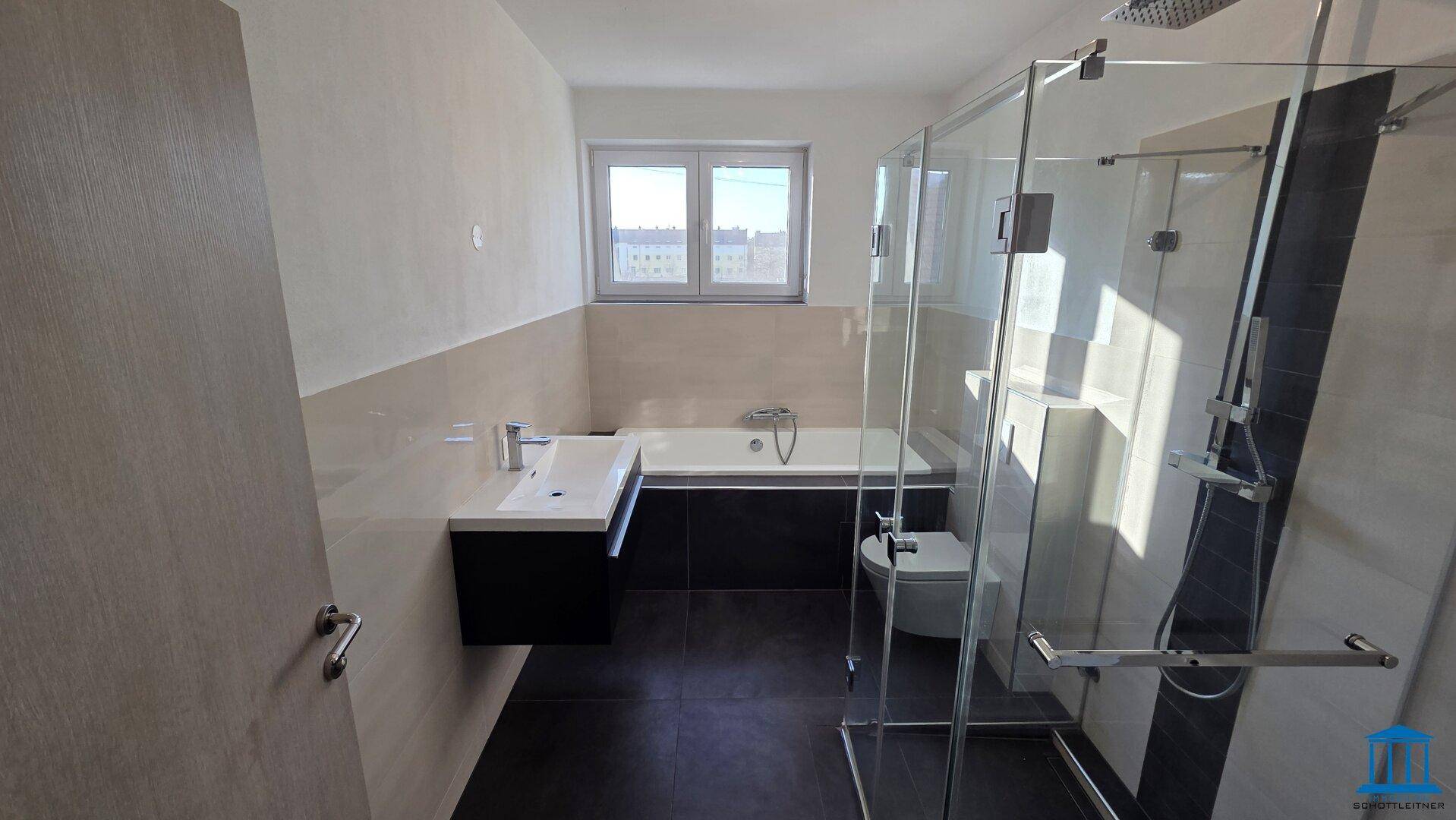 Modernes Badezimmer mit Badewanne, Duschkabine aus Glas und einem Fenster für natürliche Belichtung.