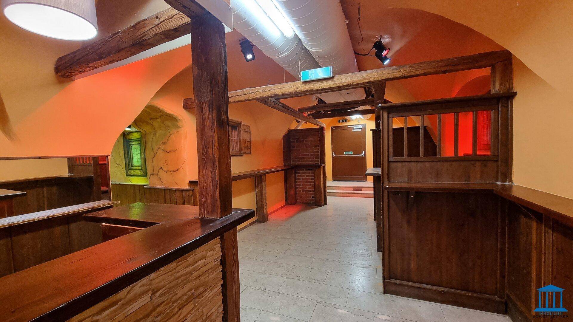 Innenansicht eines Barbereichs mit Holzbalken, gewölbten Decken und rustikalen Holzelementen.